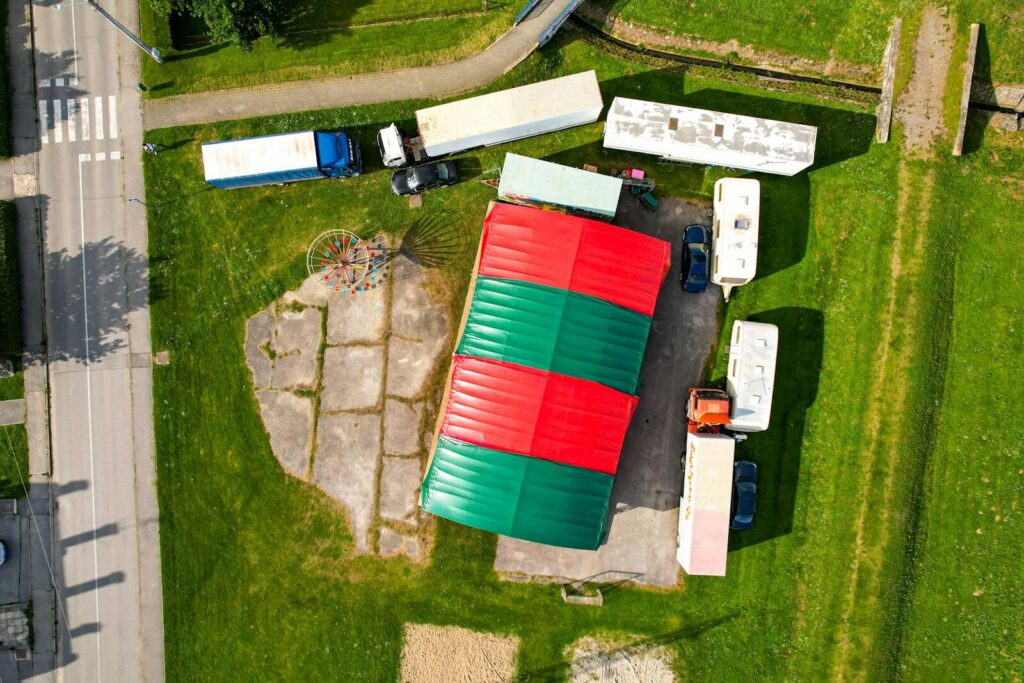 Aerial shot of a colorful circus tent with surrounding motorhomes and trucks in Garešnica, Croatia.