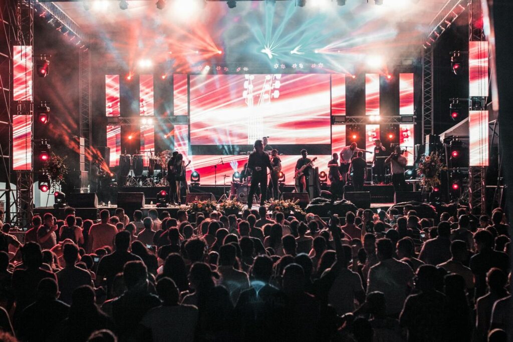 Vibrant outdoor concert event in Santa Marta with a lively crowd and colorful lighting effects.
