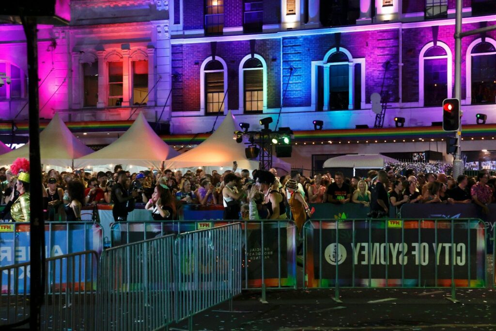 Crowd gathered at a vibrant city event at night.